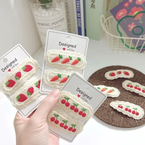 Cute embroidered strawberry and carrot hair clips with lace trim on a display card