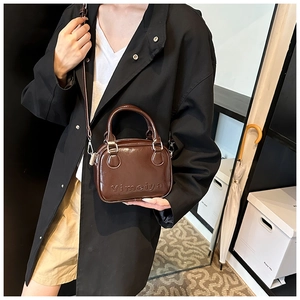 Macro detail of glossy dark brown patent leather bag with silver metal hardware