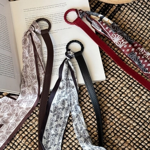 Detailed view of vintage silk scarf belts in red and black with geometric patterns