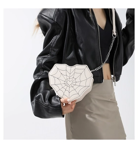 Detalle del bolso bandolera blanco en forma de corazón con costura de telaraña y cadena