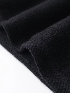 Close-up of black knit fabric texture showing high-quality woven pattern and fiber detail