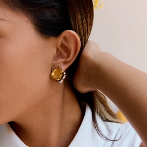 Detail of luxury irregular stainless steel earrings in gold and silver on model
