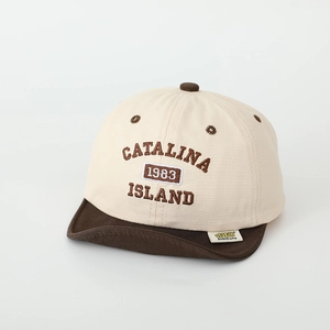 Detail of baby cotton cap showing 1983 embroidery and DiDiCute woven label on soft brim