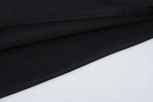 Close-up of the delicate stitching and fine knit texture on the black lace dress hemline
