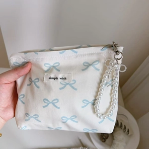 Detail of blue bow print cotton bag with pearl chain handle and simple wish label
