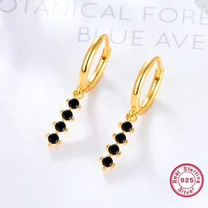 Detailed macro view of 925 sterling silver gold earrings with hanging black round zircons