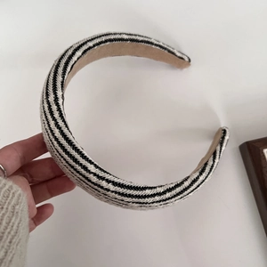 Detail showing hand-held black and white striped sponge headband with khaki lining