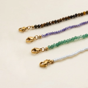 Macro detail of multi-color beaded necklaces with golden lobster clasps in studio lighting