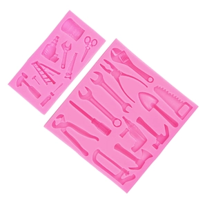Pink silicone fondant mold featuring wrench, hammer and drill tool shapes for cake decorating
