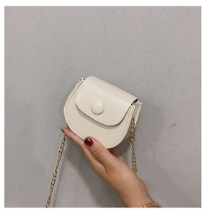 Gros plan sur un mini sac besace blanc en cuir synthétique texturé avec chaîne dorée