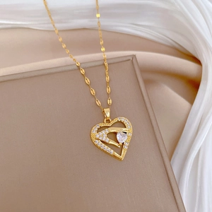Luxurious gold heart pendant necklace with shimmering crystals on soft beige fabric background