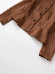 Détail de la texture en daim marron et des boutons foncés sur une veste décontractée