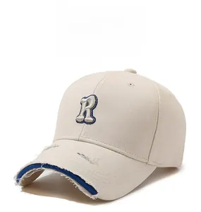 Detailed close-up of distressed brim on off-white baseball cap with blue accents