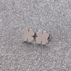 Vue rapprochée de boucles d'oreilles trèfle argentées avec finition miroir polie