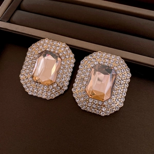 Close-up of square gold earrings with champagne stone and pave diamond details