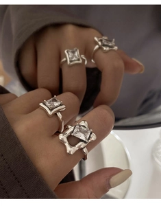 Close-up of 925 silver rings with large square crystals on irregular metal bands