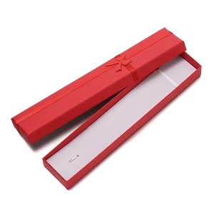 Detail view of red rectangular jewelry gift box with a ribbon bow and white foam insert