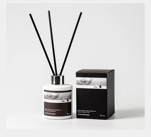 Detail view of 120ml white aromatherapy oil bottle with black reeds and matching box