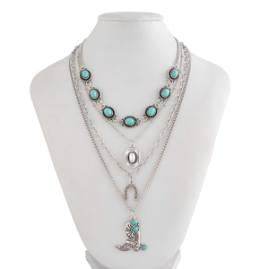 Detail of bohemian layered necklace with turquoise stones and lucky horseshoe pendant