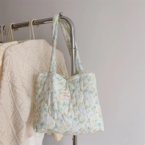 Detail of quilted floral tote bag with soft padding and intricate stitching texture