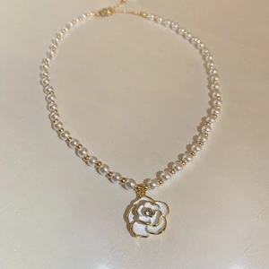 Elegant pearl choker necklace featuring a camellia flower pendant with gold accents