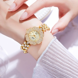 Primo piano dell'orologio GEDI dorato a forma di fiore con cristalli e quadrante