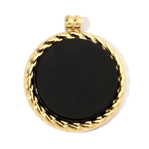 Macro detail of round gold pendant with black stone inlay and twisted rope edge texture