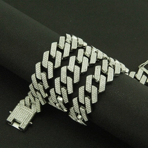 Macro shot of silver iced-out Cuban link necklace with rhinestone box clasp on black velvet