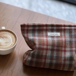 Detail of red and blue plaid textured fabric pouch with a simple wish label on a desk