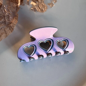 Detail of lavender heart cutout hair claw clip showing glossy acetate finish and texture