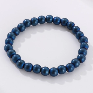 Macro detail of 8mm deep blue matte beads and metallic stones on a stretch bracelet
