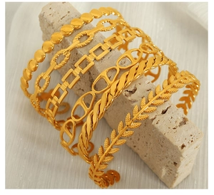 Detail of 6-piece gold-tone bracelet set including Cuban link and hollow leaf designs