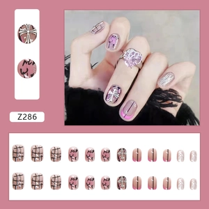 Short nude pink press-on nails with black graffiti and silver cross motifs set