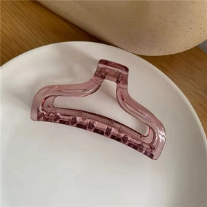 Macro shot of translucent smoky red acrylic hair claw clip with cutout geometric design