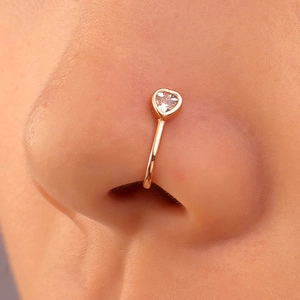 Close-up of a gold heart-shaped nose cuff with sparkling cubic zirconia on a model