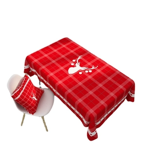 Red Christmas tablecloth and pillowcase with white reindeer silhouettes in plaid pattern