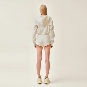 Vue arrière du sweat à capuche blanc crème ajusté et du short de sport assorti pour femmes