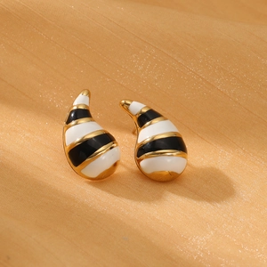 Minimalist gold teardrop earrings with elegant striped enamel finish on golden fabric