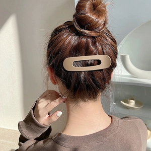 Minimalist khaki matte rectangular hair clip styling a bun on long brown hair