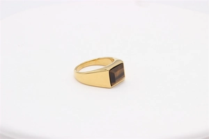 Detail shot of men's gold signet ring featuring a rectangular brown tiger eye gemstone