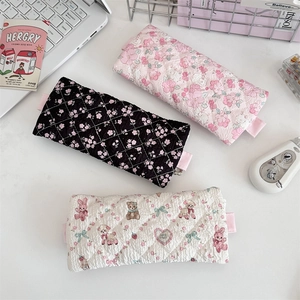 Detailed top view of three quilted lace pencil cases in floral and animal prints