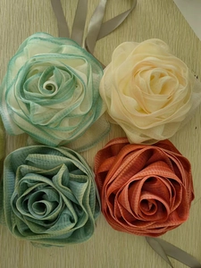 Detail van handgemaakte gaasroosbloemen in pastel munt, beige en terracotta kleuren