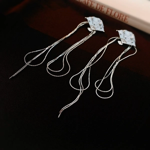 Detail of silver fan-shaped earrings with light blue enamel and long tiered tassels