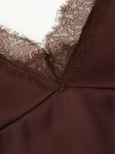 Close-up of deep brown satin top with delicate eyelash lace detailing on V-neckline
