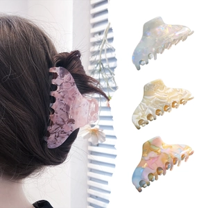 Large acetate shark hair claw clips in colorful marble patterns shown on model and white background