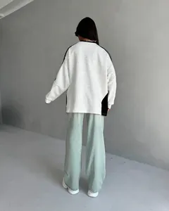 Back view of a grey oversized color-block sweatshirt and light blue wide-leg jeans