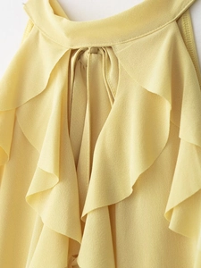 Detail of yellow halter neck top with ruffled layers and delicate tie-up collar texture