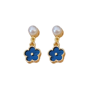 Elegant gold flower earrings with white pearl studs and blue petal pendants on white background