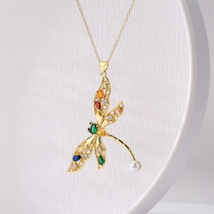 Détail du pendentif libellule avec pierres précieuses colorées et accent de perle blanche