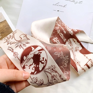 Detail of silk twilly scarf featuring rust red world map print and floral pattern